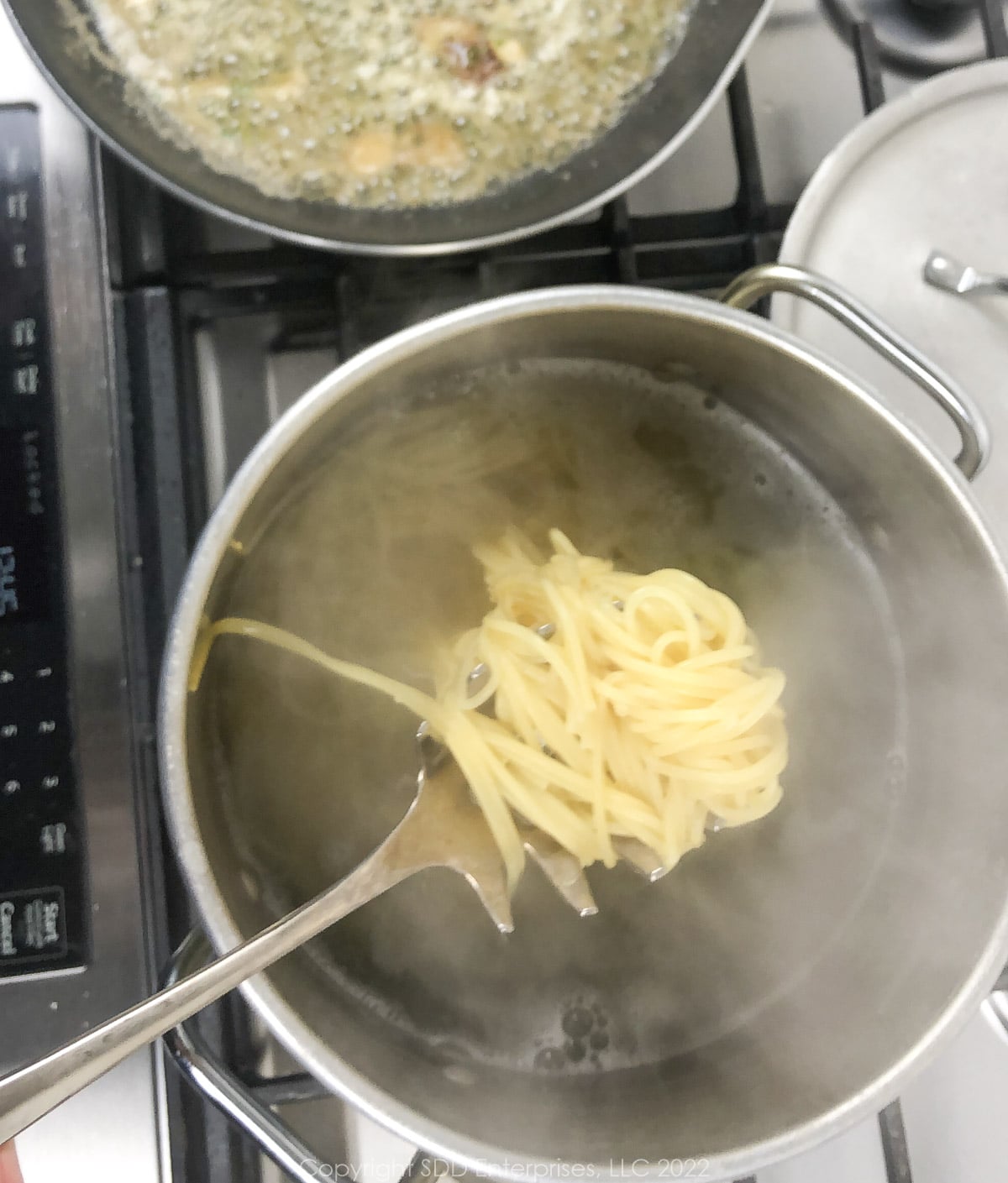taking cooked pasta out of boiling water