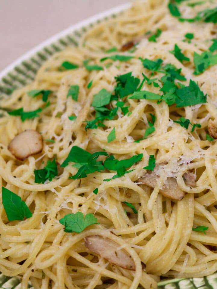 spaghetti bordelaise with parsley garlic on a green and white platter