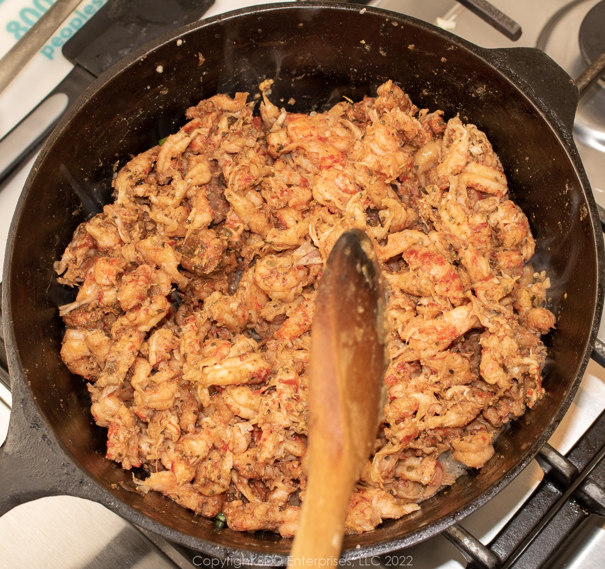 crawfish tails being mixed into butter