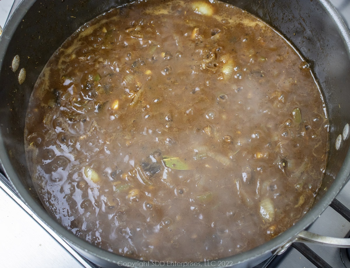 simmering brown gravy in a Dutch oven