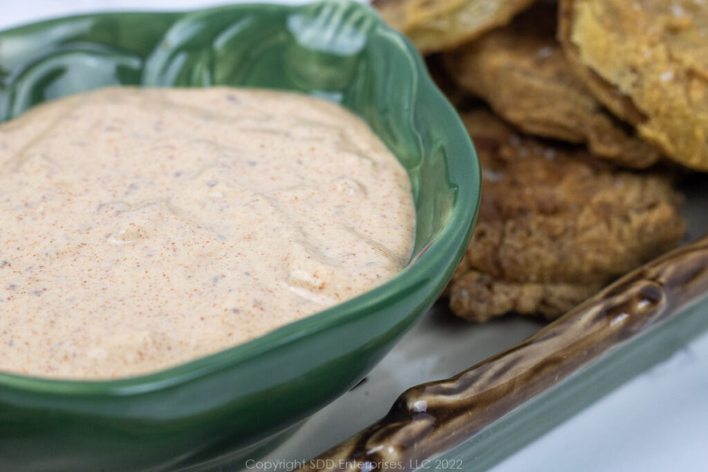 white remoulade sauce in a green bowl with fried green tomatoes