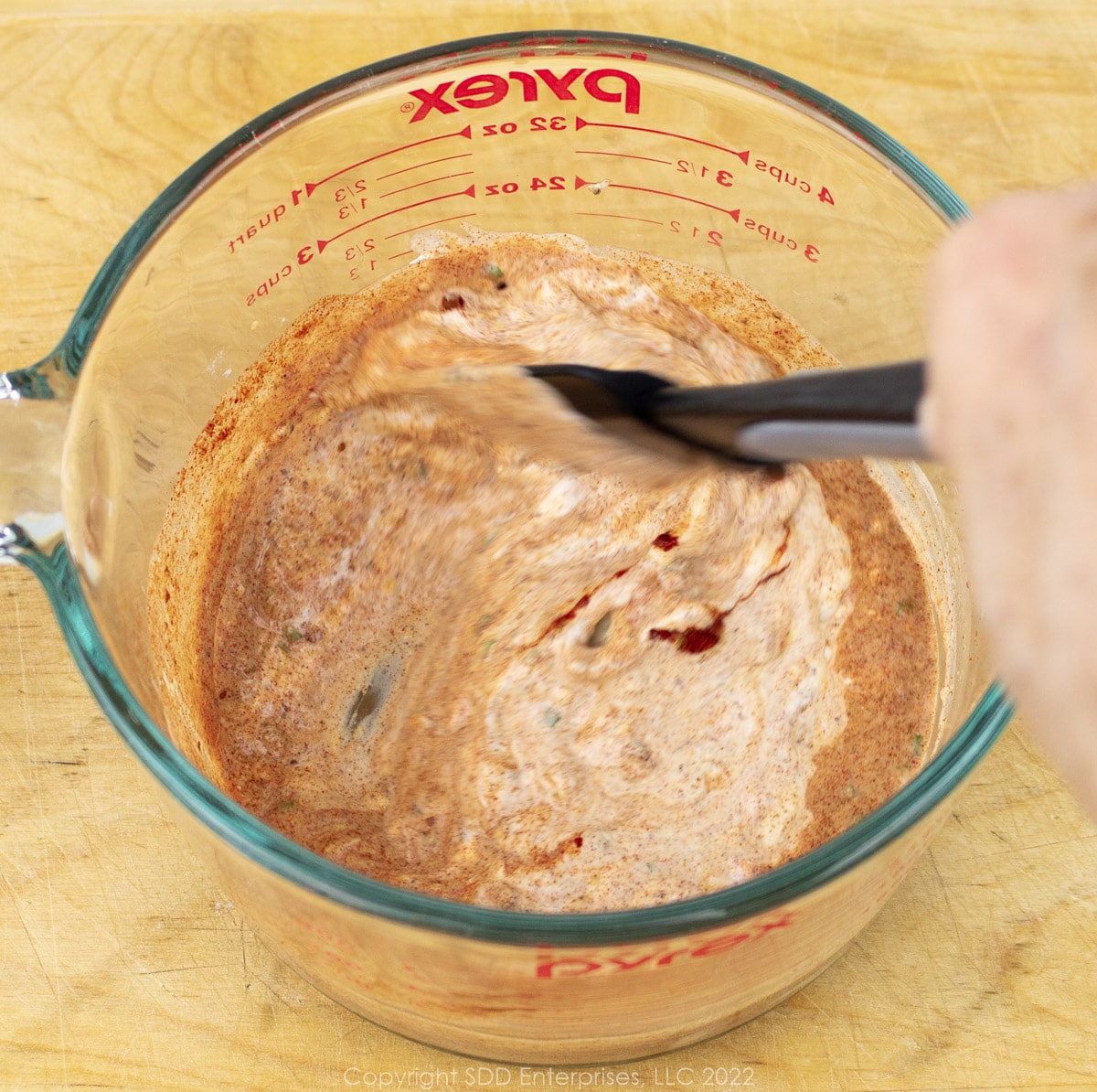 mixing ingredients for white remoulade sauce in a large measuring cup