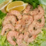 white remoulade sauce mixed with shrimp on a bed of lettuce