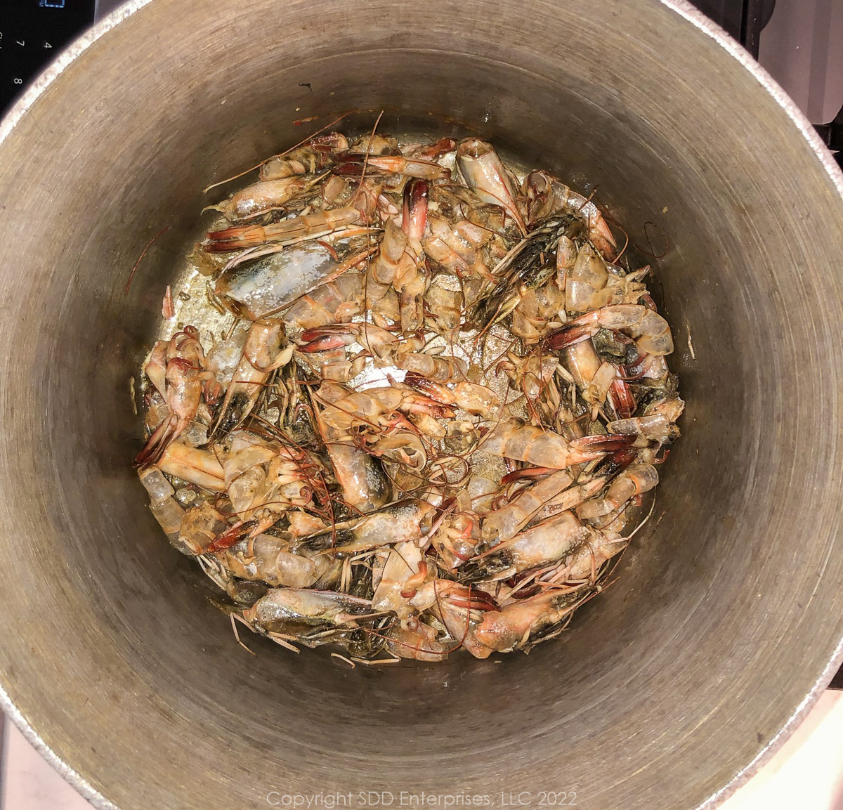 shrimp shells and heads sautéing in margarine in a stockpot