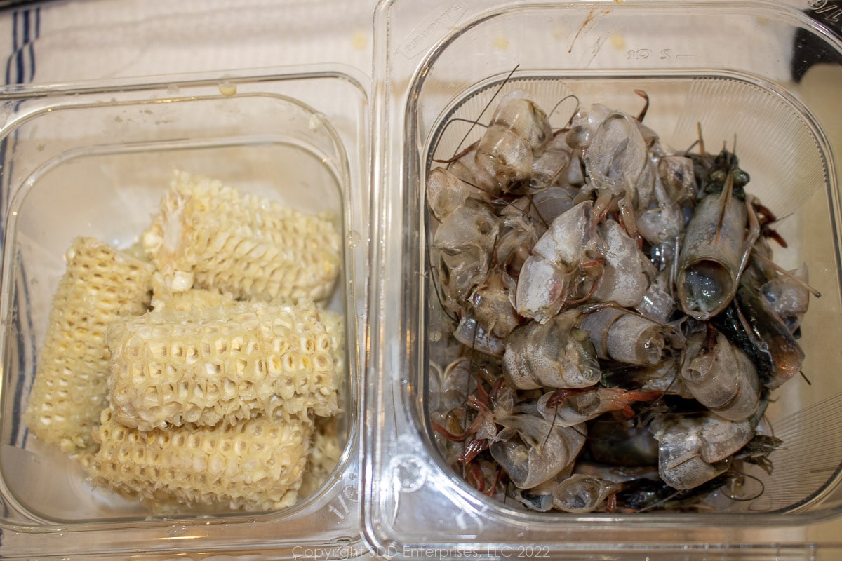 scraped corn cobs and shrimp shells in prep bowls