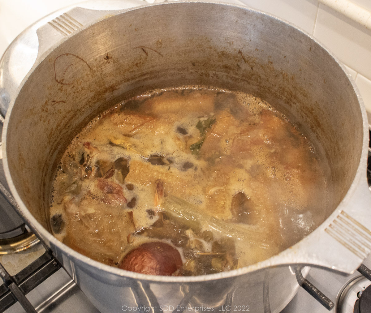 simmering corn and shrimp stock in a stockpot