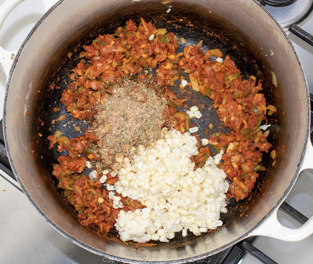 corn and herns added top veggies in a Dutch oven