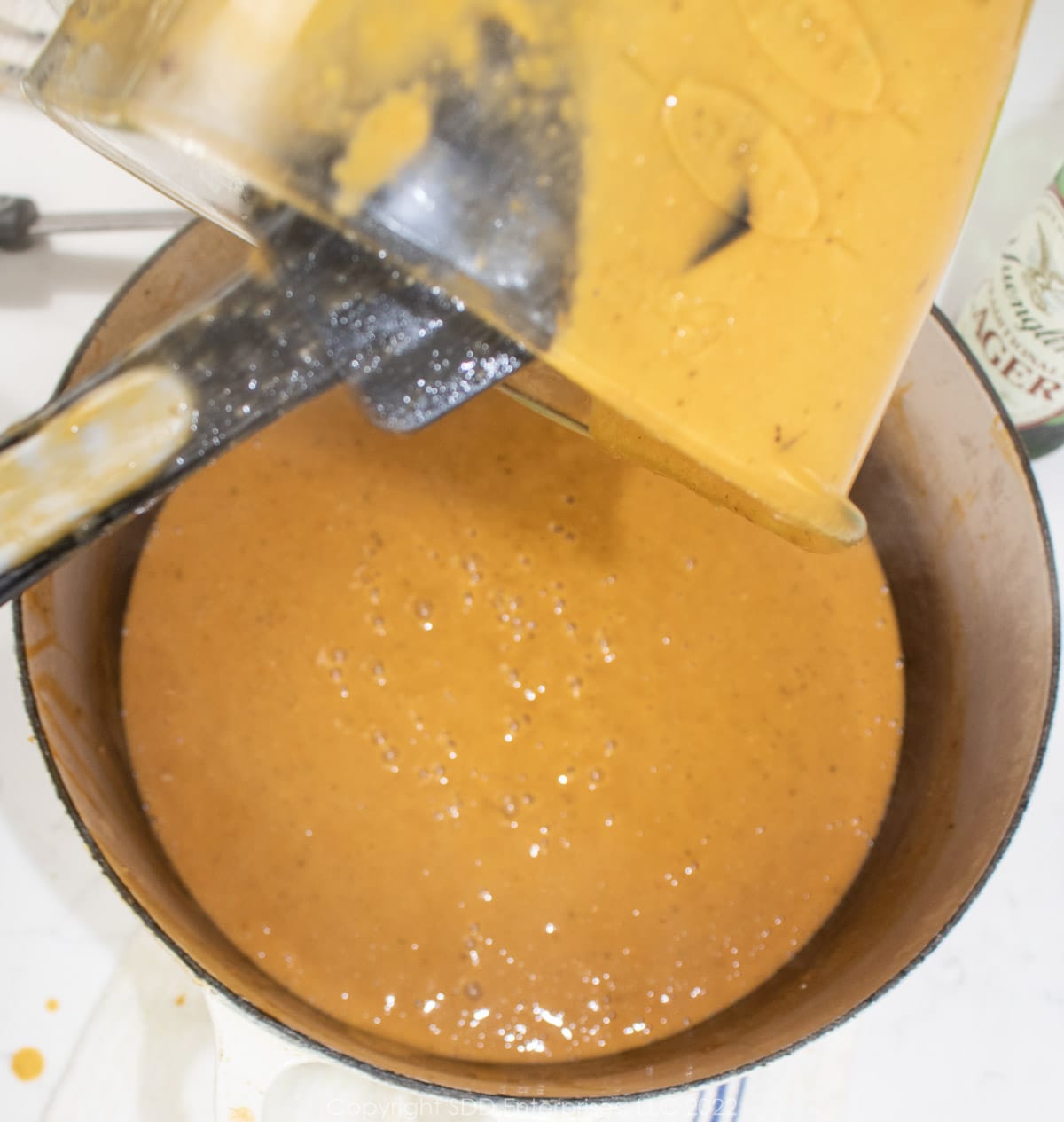 pureed bisque pouring into Dutch oven