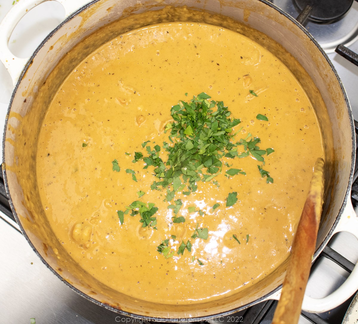 corn and shrimp bisque with garnish in a Dutch oven