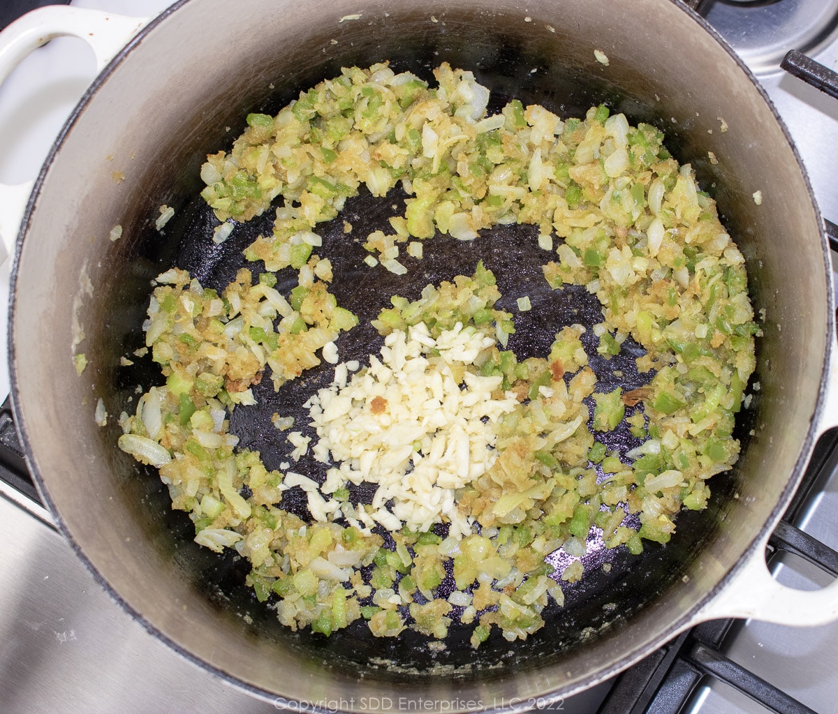 garlic with the Trinity and roux in a Dutch oven