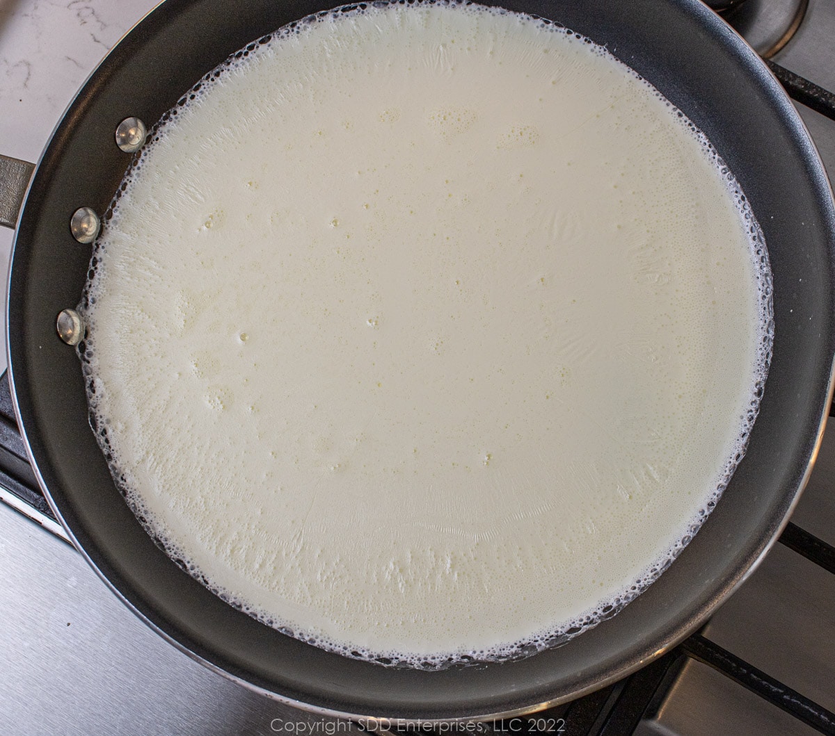 heavy cream on a low simmer in a sauté pan