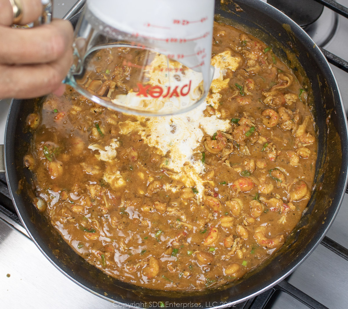 cream and sheery added to crawfish tails in a brown sauce