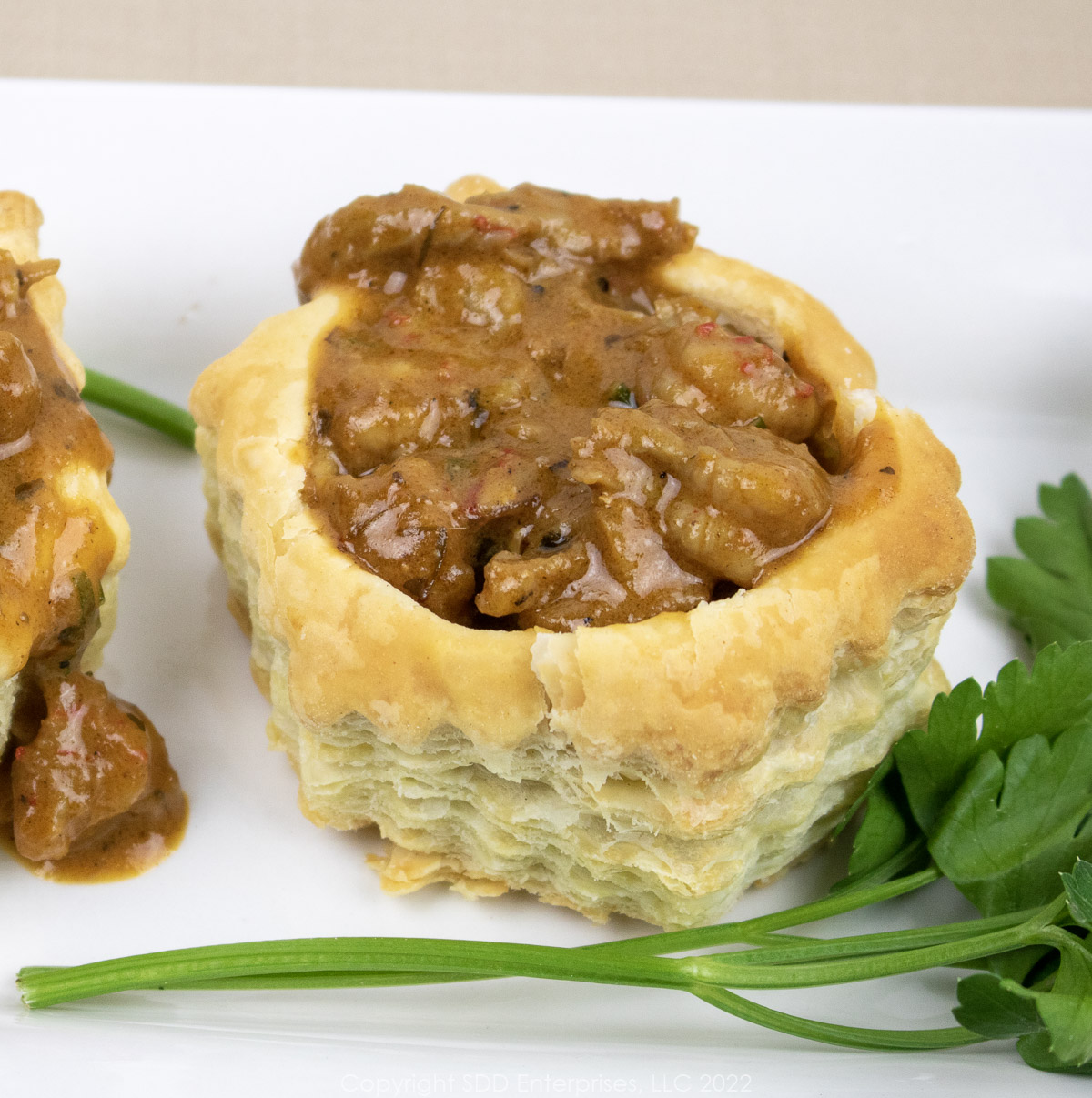 crawfish vol au vent on a white platter with parsley garnish