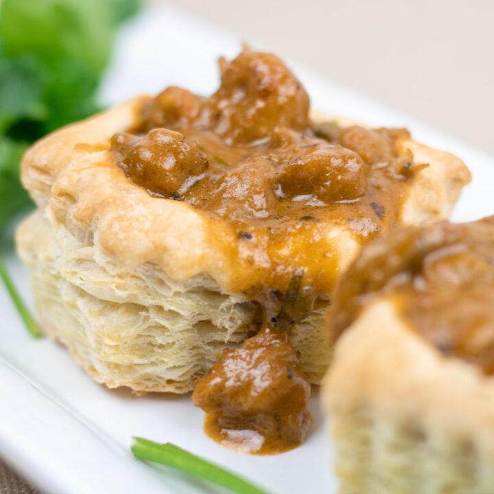 crawfish in sauce ina puff pastry on a white platter with garnish