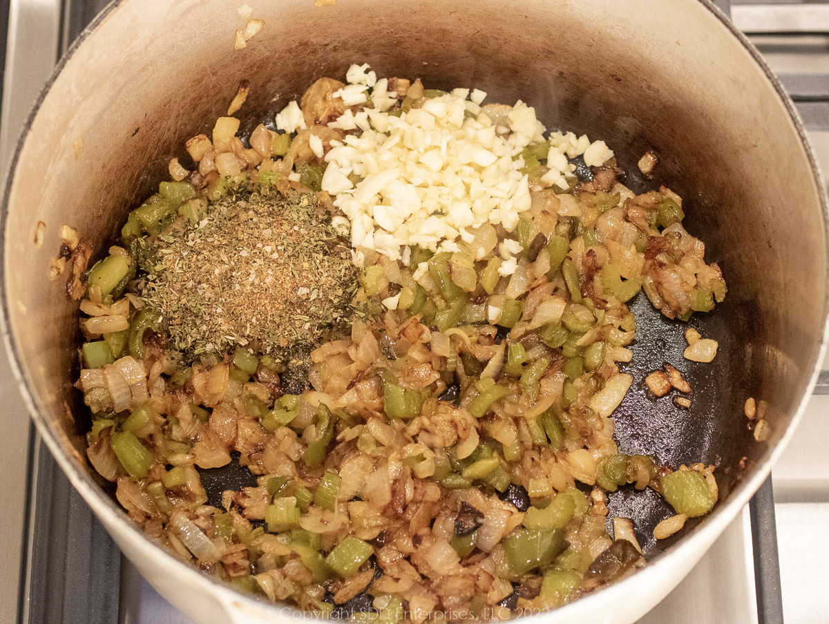 garlic and spices blended with vegetables in a Dutch oven