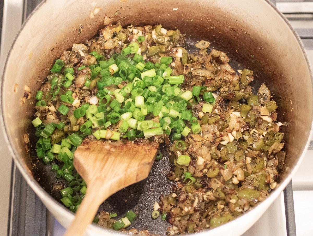 green onions added to sauteing vegetables in a Dutch oven