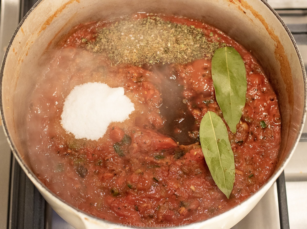 seasonings added to simmering sauce in a Dutch oven