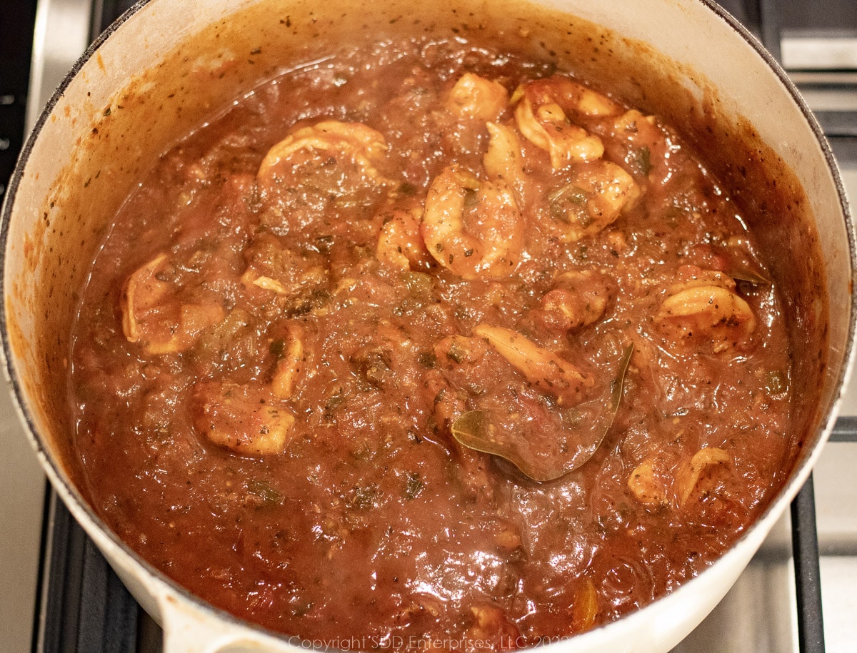 simmering creole sauce with shrimp in a Dutch oven