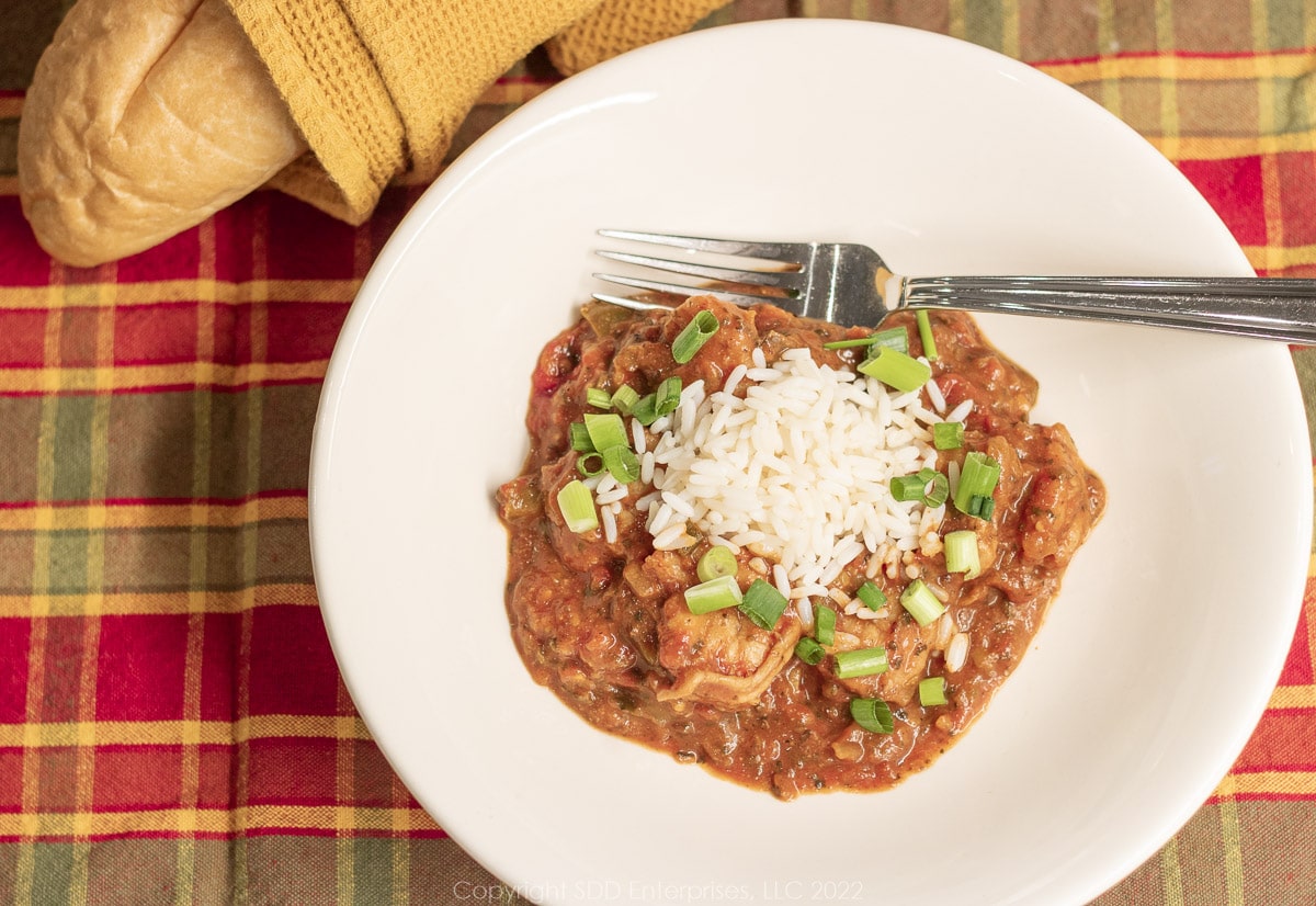 shrimp creole with rice and garnish in a white bowl with french bread