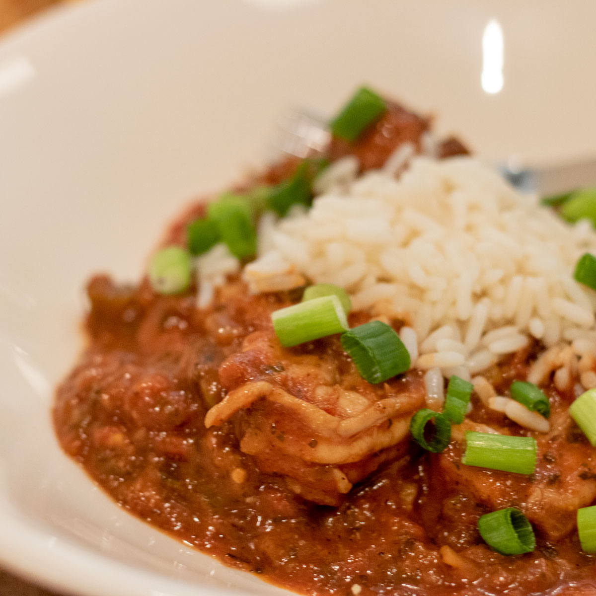 shrimp creole with rice and garnish in a white bowl