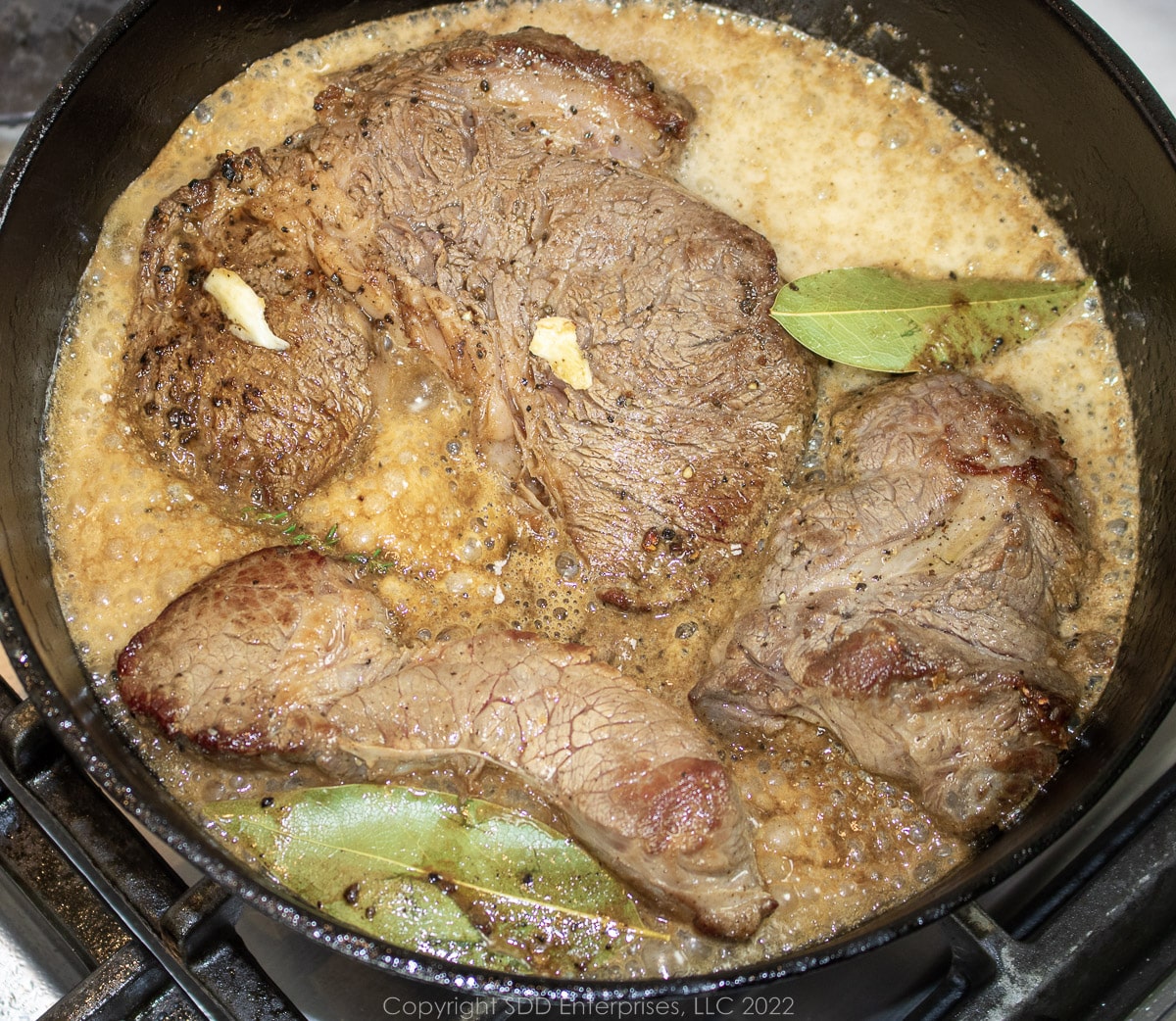 beer being added for a braise of beef chuck roast in a Dutch oven
