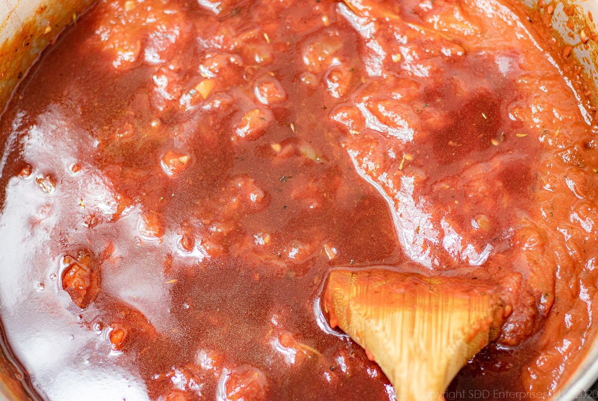 red wine added to simmering tomato sauce in a Dutch oven