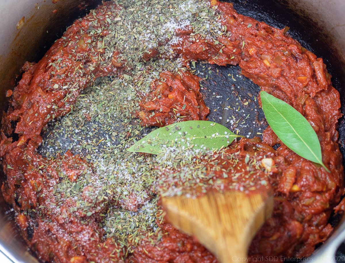 hers and spices added to sautéed vegetables and tomato paste in a Dutch oven