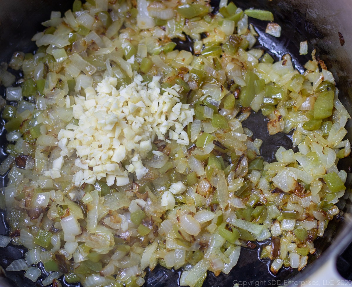 chopped garlic added to sautéed vegetables in a Dutch oven