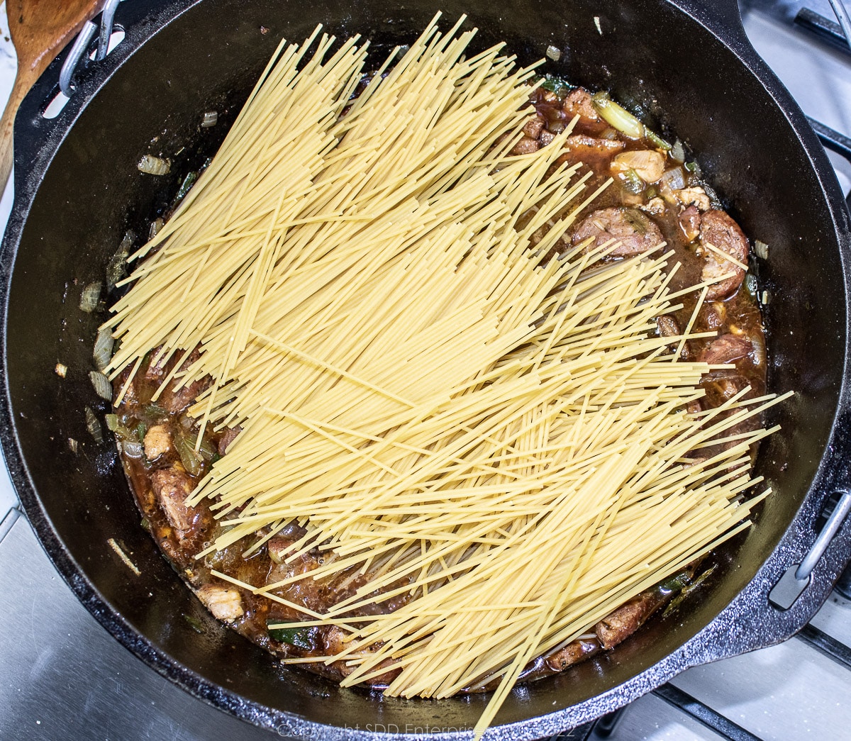 dry spaghetti added to stock in a Dutch oven