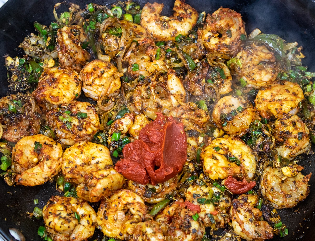 tomato paste added to shrimp mix in a skillet