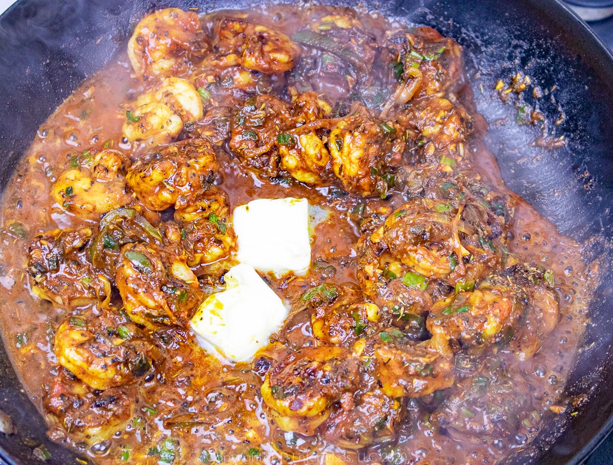 liquid ingredients added to a skillet with shrimp and vegetables