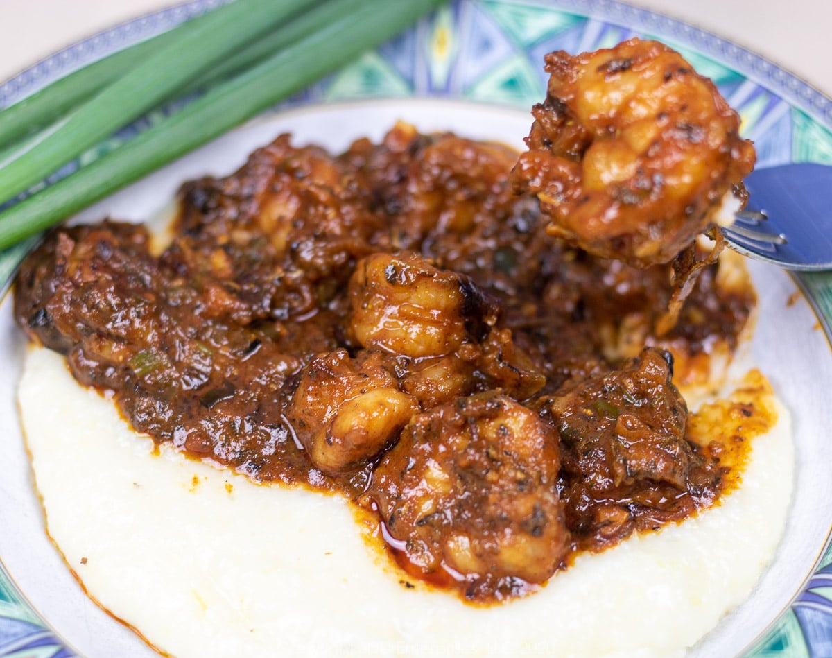 shrimp and grits in a blue green bowl with garnish