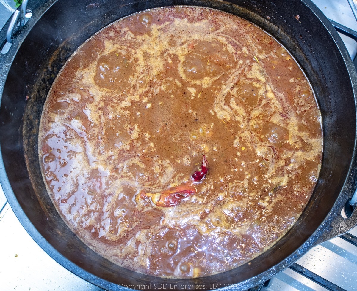 stock and tomatoes simmering in a Dutch oven