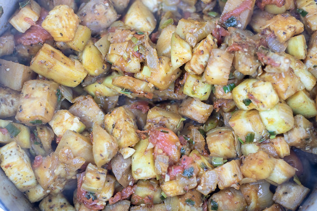 cubed eggplant added to sautéing vegetables in a Dutch oven