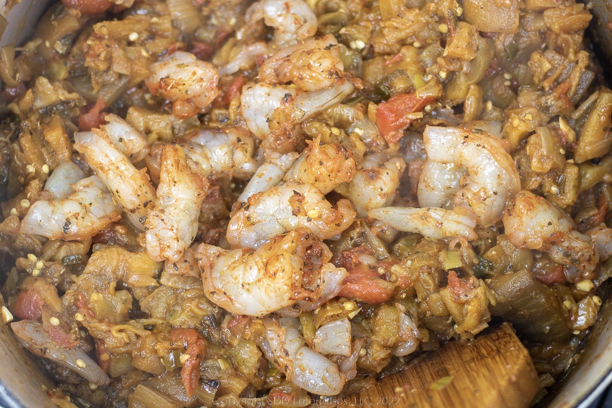 uncooked shrimp added to sauteing vegetables in a Dutch oven