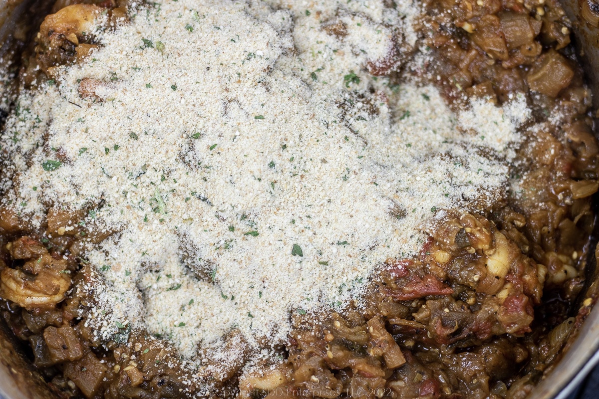 breadcrumbs added to vegetables and shrimp in a Dutch oven