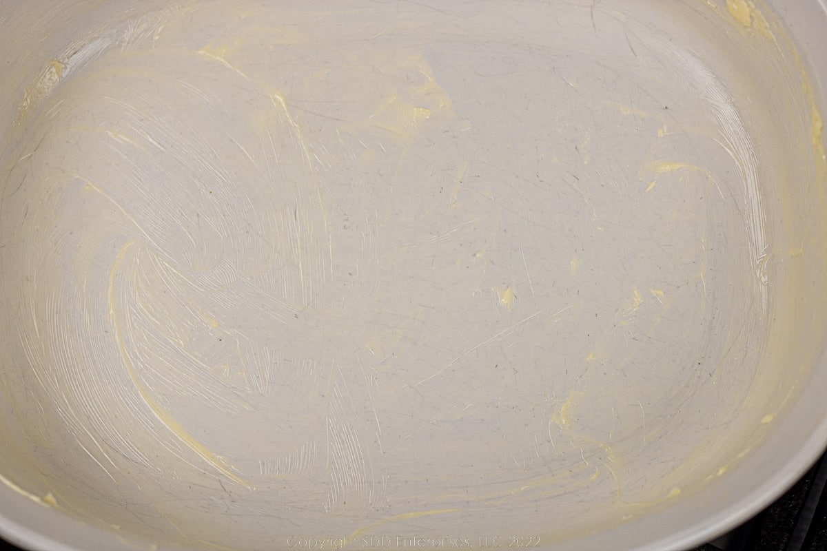 white baking dish coated with butter