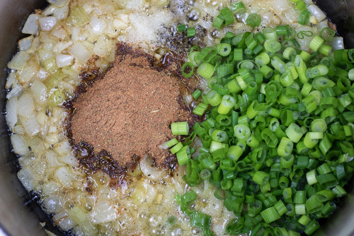 seasonings added to butter and garlic in a Dutch oven