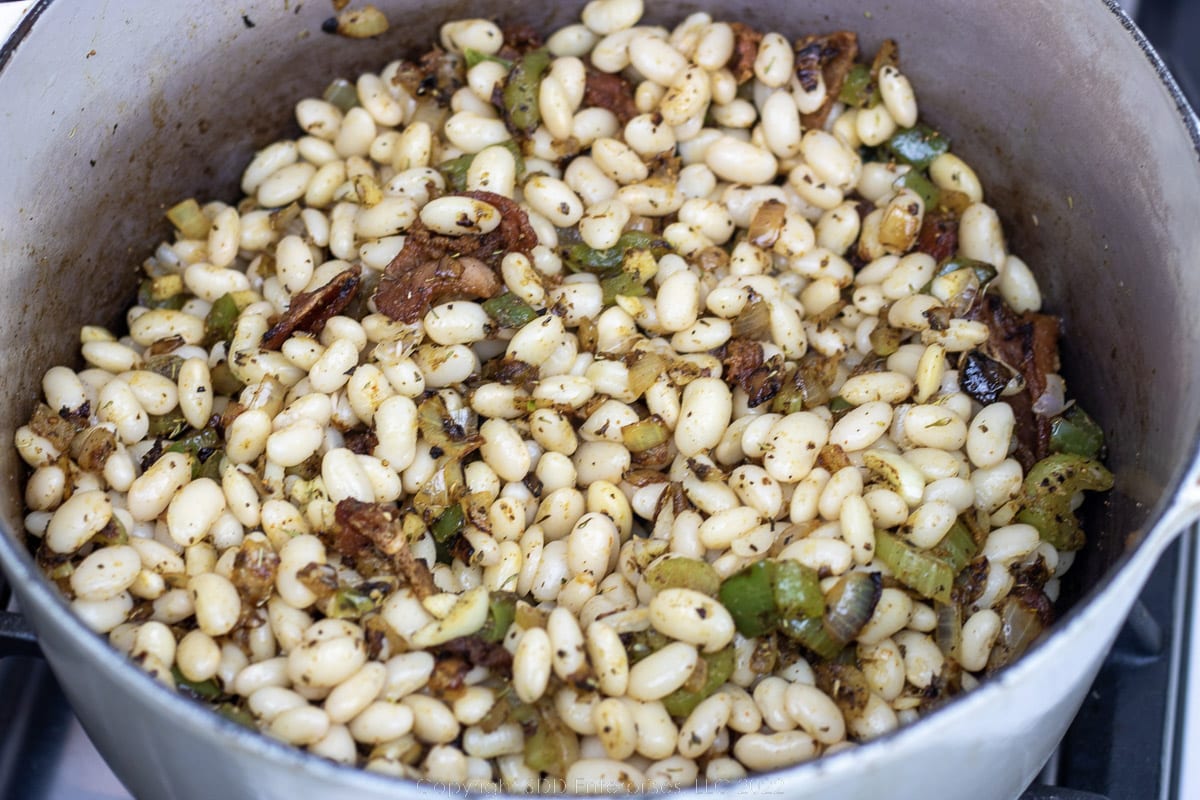 soaked dry beans added to seasonings in a Dutch oven