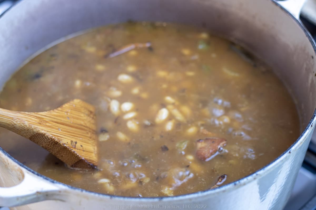 simmering white beans in a Dutch oven