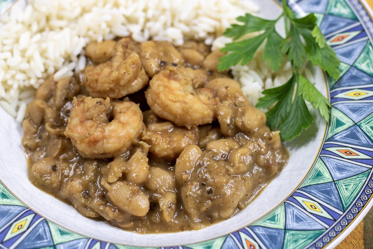 white beans and shrimp with rice and garnish in a blue-green bowl