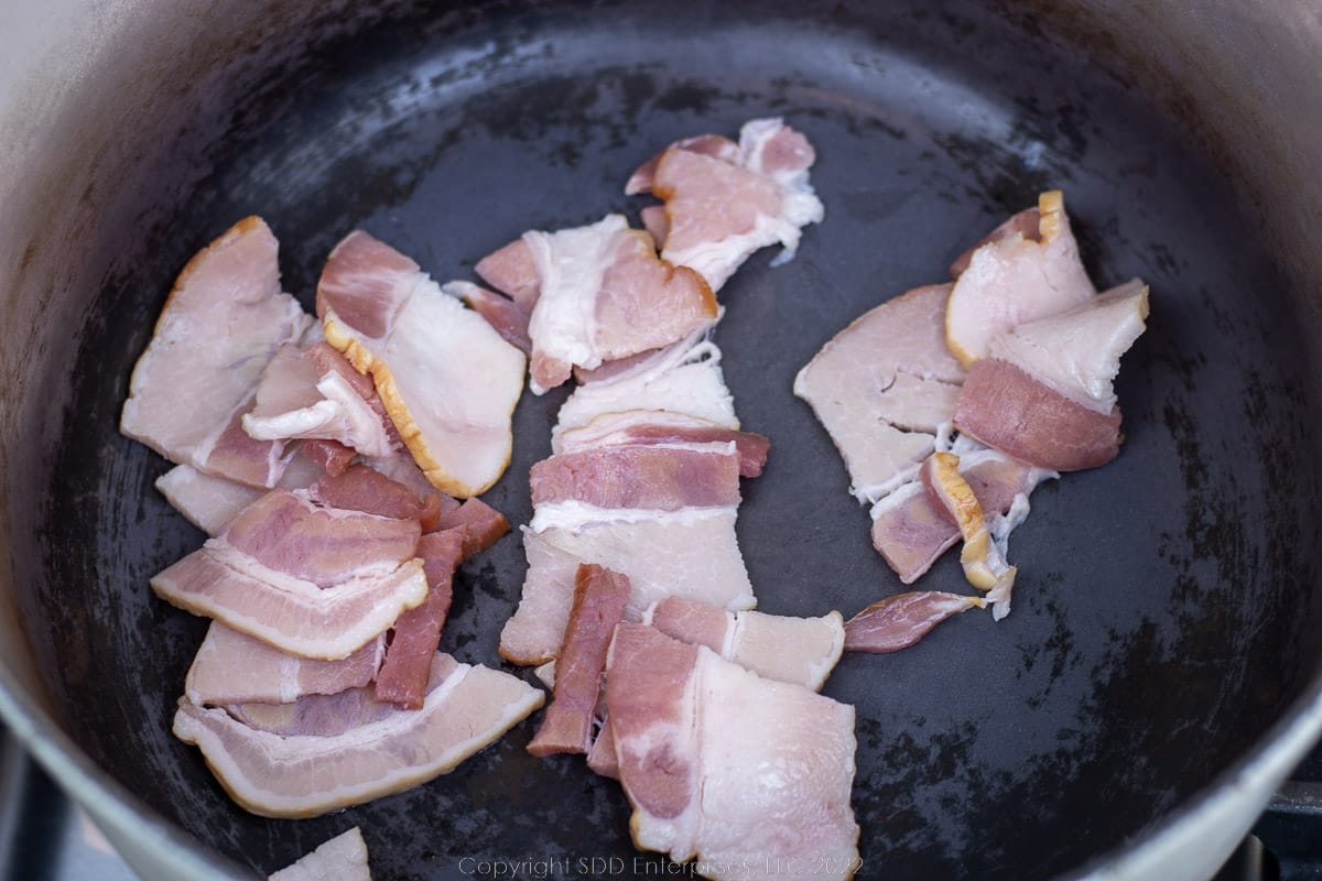 sliced bacon rendering in a Dutch oven