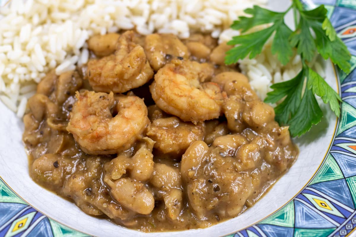 white beans and shrimp with rice and garnish in a bowl