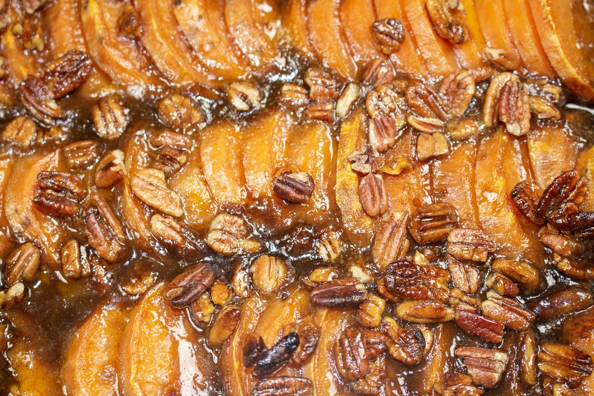 roasted sweet potatoes with cane syrup and pecans in a baking dish