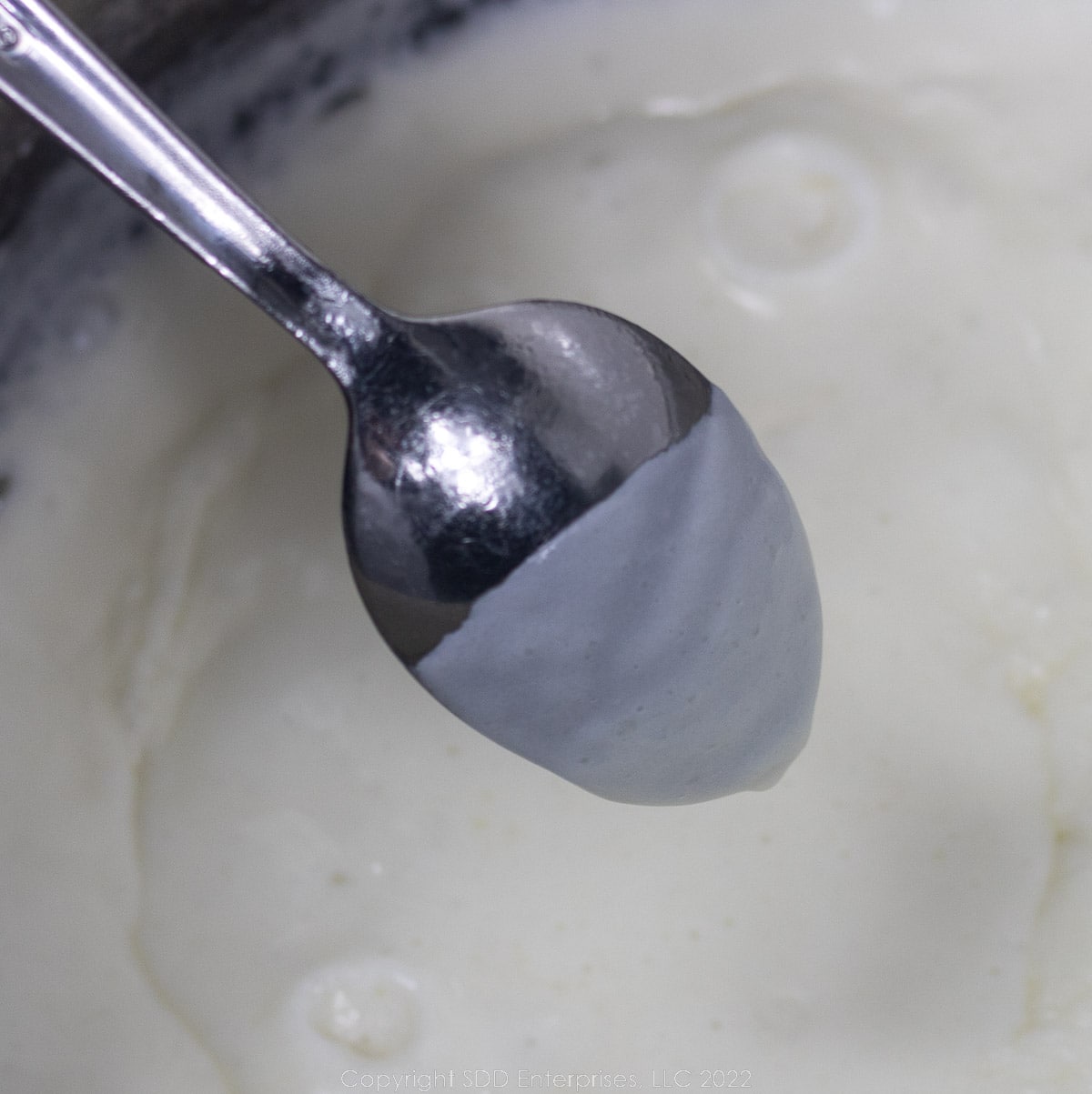 bechamel sauce coating a spoon