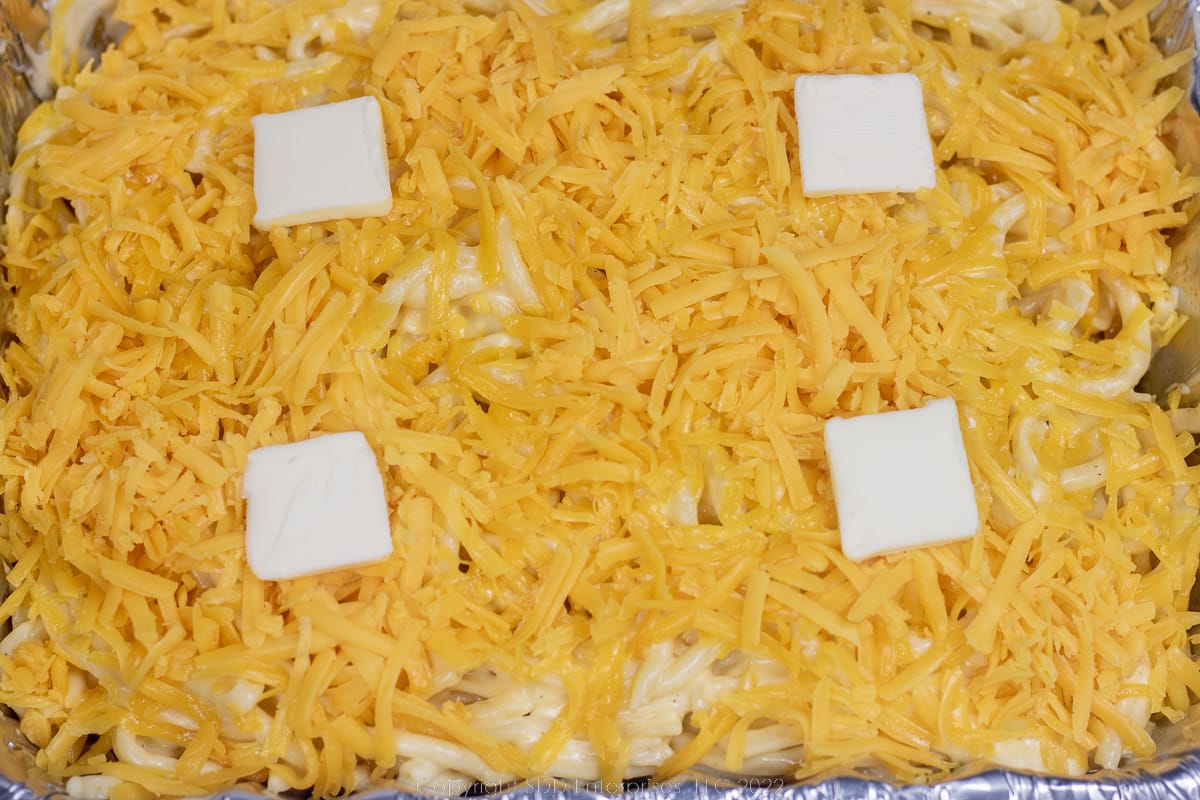 mac and cheese topped with butter ready for the oven