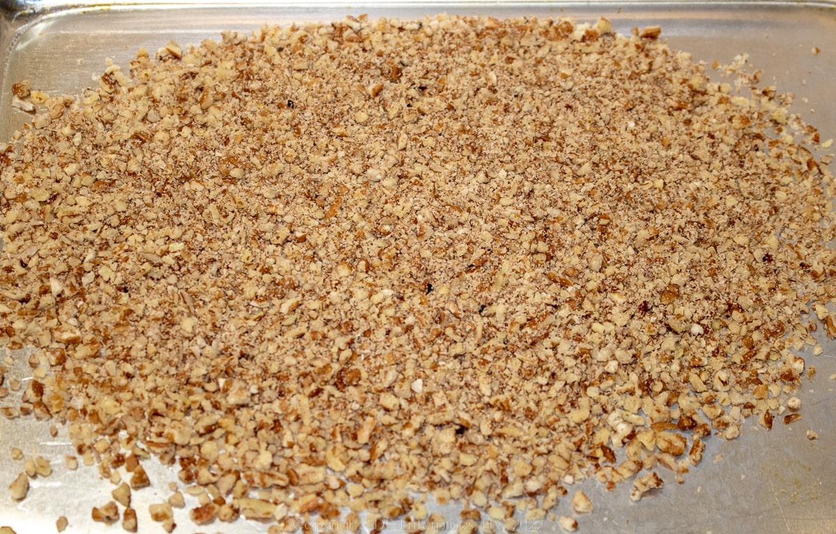 Crushed pecans on a baking sheet