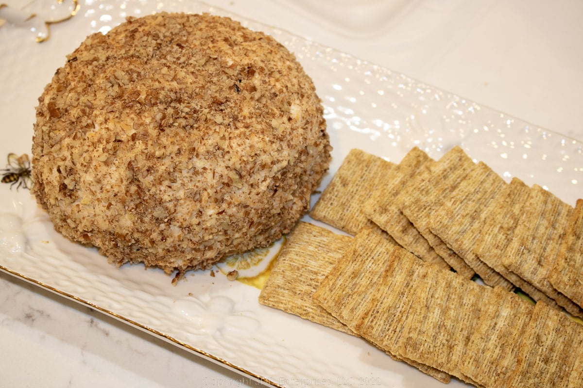 Cheese ball on a serving platter with crackers