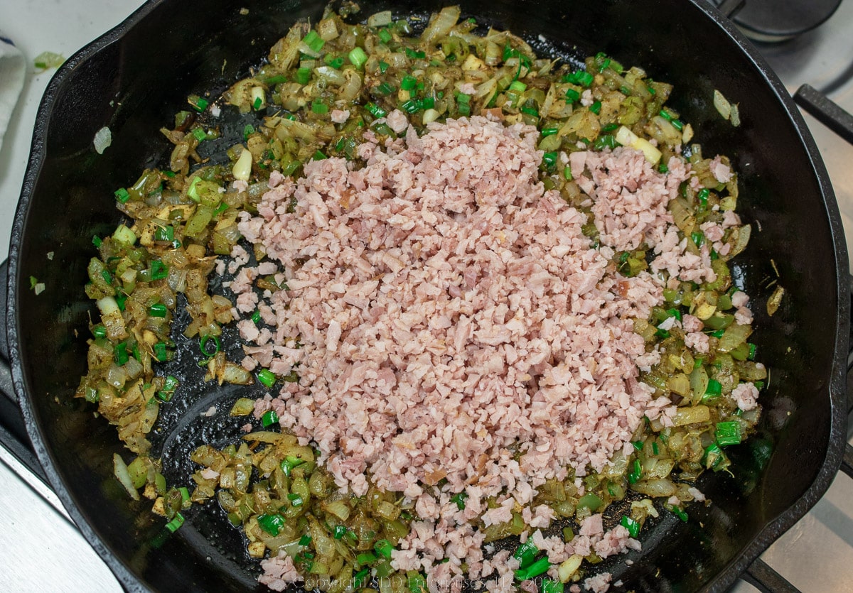 ham and vegetables frying in a cast iron skillet