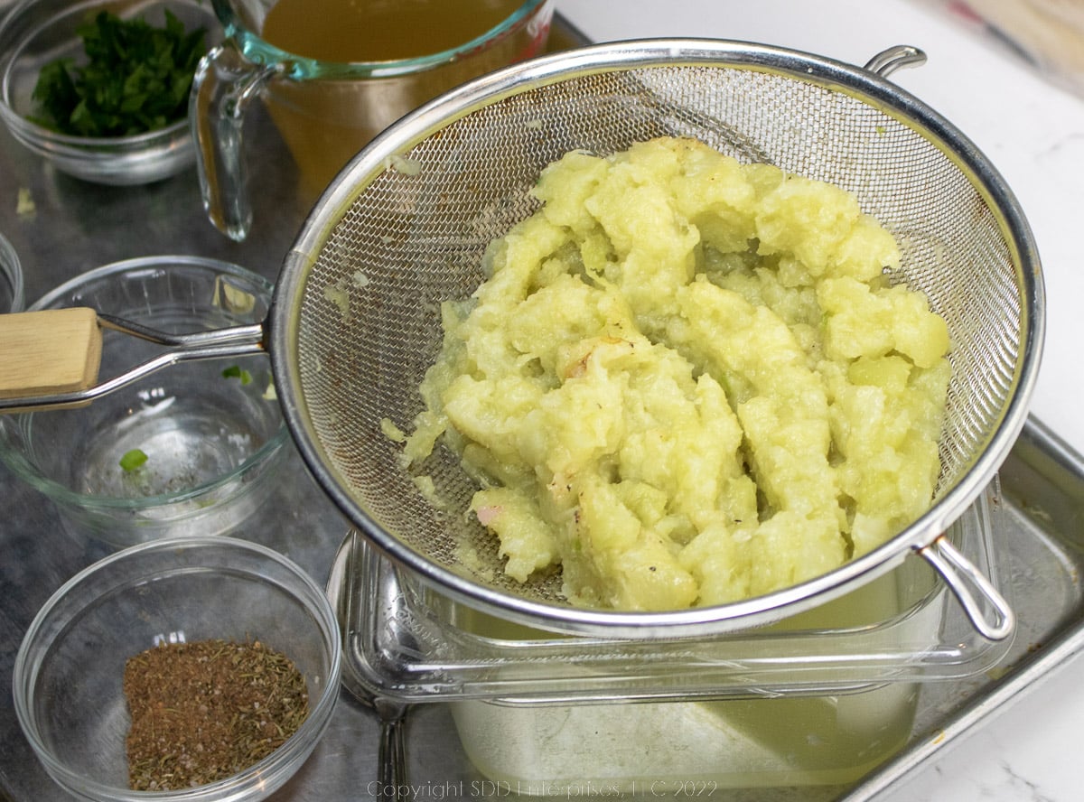 mashed mirliton flesh in a strainer